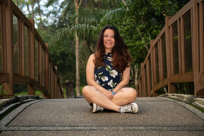 Portrait of young woman sitting on sofa at home