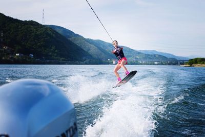 Full length of woman jumping in sea