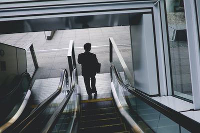 Rear view of man standing on staircase