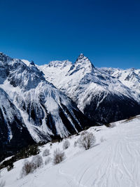 Scenic view of snowcapped mountains against clear blue sky