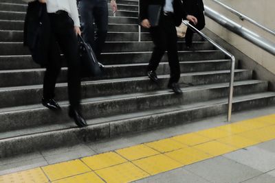 Low section of people walking on stairs