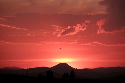 Scenic view of silhouette mountains against sky at sunset