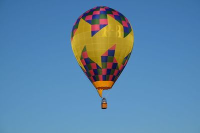 Multi colored hot air balloon against clear blue sky