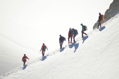 Low angle view of people walking on snow covered landscape