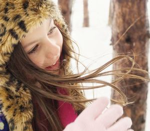 Close-up of cute girl wearing fur hat during winter