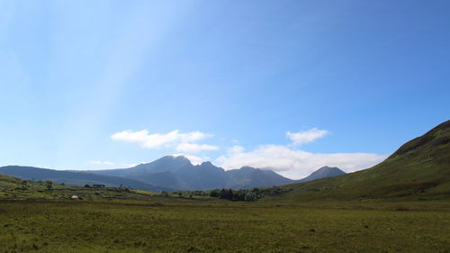 Scenic view of green landscape and mountains against sky