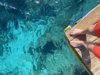 Low section of woman standing by sea