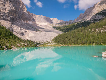 Scenic view of lake and mountains against blue sky