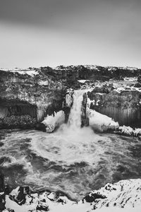 Scenic view of waterfall against sky