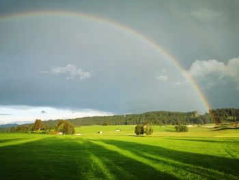 Scenic view of rainbow over landscape against sky