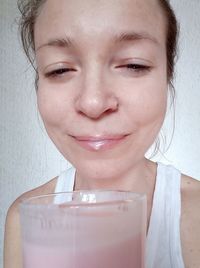 Close-up portrait of a beautiful young woman drinking glass