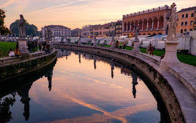 Canal at prato della valle against sky during sunset