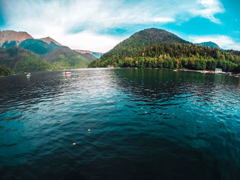 Scenic view of lake by mountains against sky