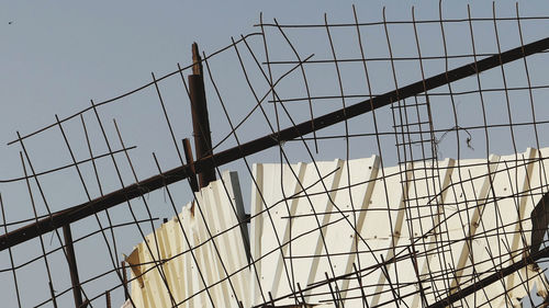 Low angle view of fence against sky