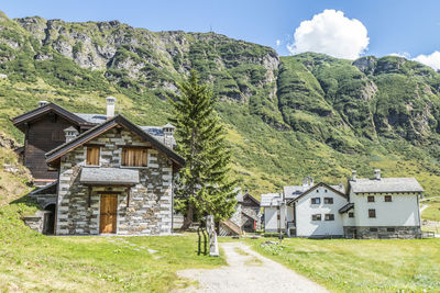 House amidst trees and buildings against sky