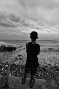 Full length of boy standing on beach against sky