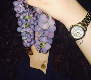 Close-up of hand holding purple flowers