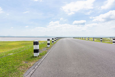 Diminishing perspective of empty road against cloudy sky