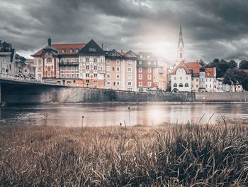 Buildings in city against cloudy sky