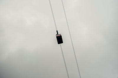 Low angle view of overhead cable car against sky