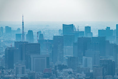 Aerial view of buildings in city against sky