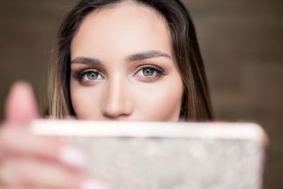 Close-up portrait of young woman using smart phone