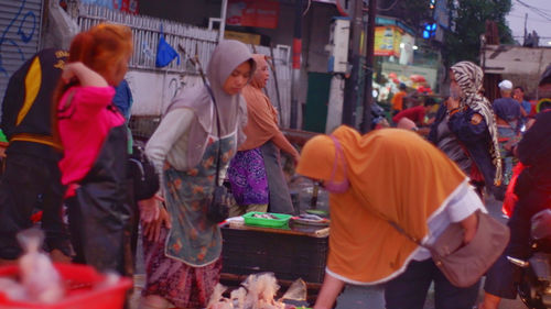 Group of people at market stall in city