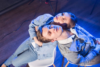 High angle view of mother and daughter against blue wall