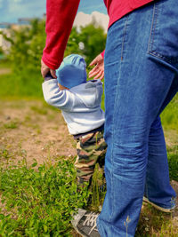 Low section of father and child on field