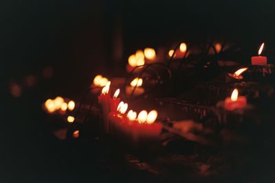 Close-up of lit candles burning at night