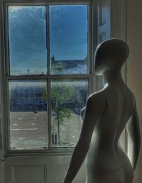 Rear view of woman looking through window