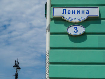 Low angle view of sign against blue sky