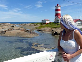 Rear view of woman on beach against sky