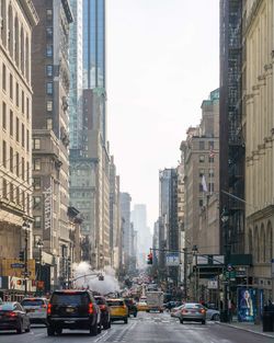 Traffic on road amidst buildings in city