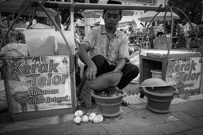 Man sitting at market stall