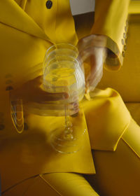 Close-up of hand holding yellow glass