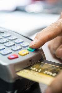 Cropped hands of woman swipping credit card