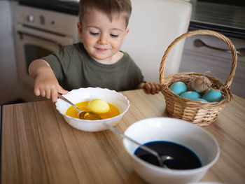 Portrait of cute baby boy eating food on table