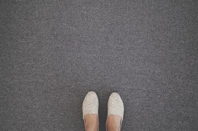 Low section of woman standing on tiled floor