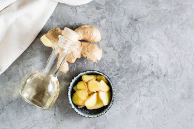 Ginger serum in a bottle and chopped ginger in a bowl on the table. alternative natural cosmetology. 