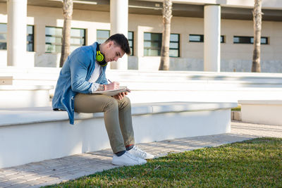 Side view of young man using mobile phone