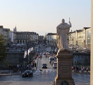 Statue in city against sky