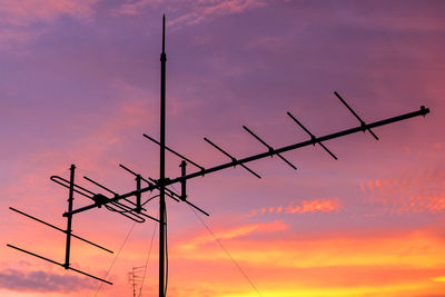 Low angle view of antenna against cloudy orange sky during sunset