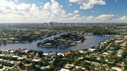 High angle view of city by river against sky