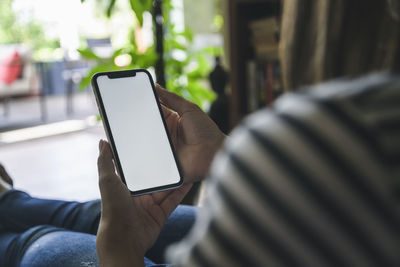 Young woman using smartphone at home