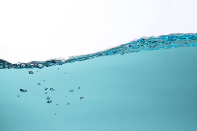 Close-up of water splashing against blue sky