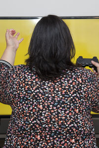 Rear view of woman standing in hat