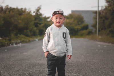 Portrait of young man standing on road