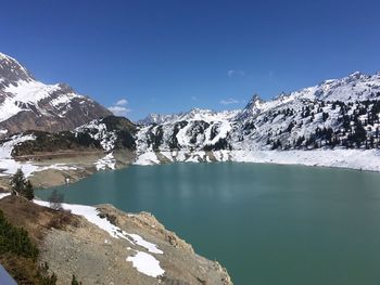 Scenic view of lake by mountains against sky