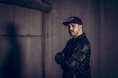 Portrait of mature man standing against wall